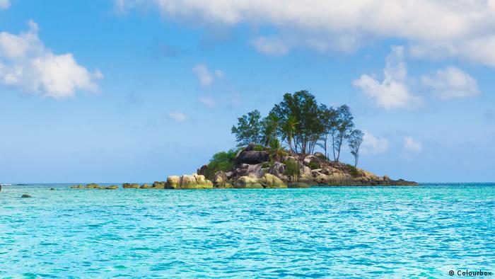 Eine kleine Palmen-bewachsene Insel im Meer