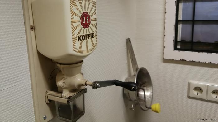 Eine alte Kaffeemühle hängt an einer Wand