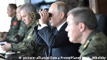 September 13, 2018 - Chita, Siberia, Russia - Russian President Vladimir Putin, center, with Defence Minister Sergei Shoigu, left, and Chief of the General Staff General Valery Gerasimov observe the Vostok-2018 multi-national war games at the Telemba training grounds September 13, 2018 near Chita in Eastern Siberia, Russia |