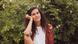 Fashion blogger Mia Marjanovic sits in front of a green bush with pink flowers Fashion blogger Mia Marjanovic sits in front of a green bush with pink flowers