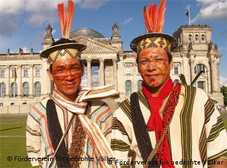 Moises and Benki Piyako in Brazilian dress in front of the German parliament building, the Reichstag