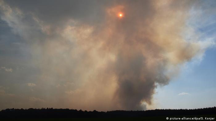 Sun peeking through billowing smoke (picture-alliance/dpa/S. Konjer)