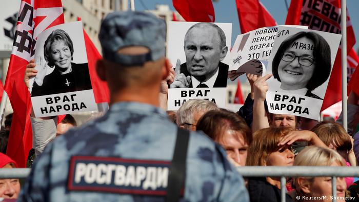 Protesters against the pension reform hold placards branding Russian politicians including Russian President Vladimir Putin enemies of the people