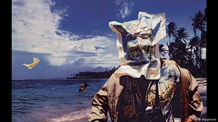  Album Cover 10cc Bloody Tourist (Hipgnosis) Ein Mann im Hawaiihemd und trenchcoat an einem traumhaften Palmenstrand. Im Hinter grund steht eine langhaarige Frau im Wasser. Der Wind hat dem Mann eine Landkarte ins gesicht geweht