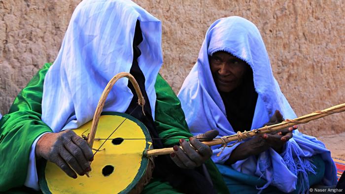 The photos reflect Libyan landscapes, customs, traditions and crafts. One of the women in this photo by Naser Amghar plays a stringed gourd, a traditional musical instrument. (Naser Amghar)
