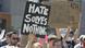 Protester holding up sign reading: 'Hate solves nothing' Protester holding up sign reading: 'Hate solves nothing'