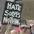 Protester holding up sign reading: 'Hate solves nothing'