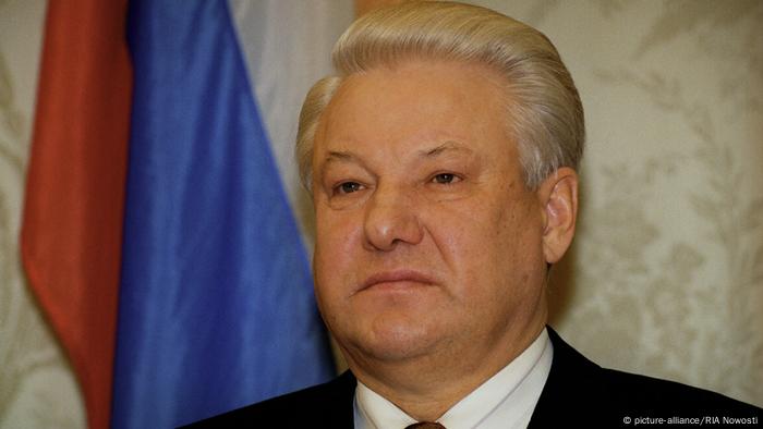 Boris Yeltsin stands in front of the Russian flag