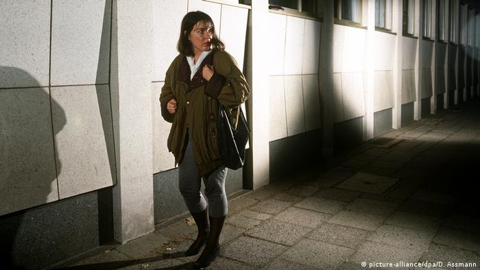 Symbolbild: Angst - Frau geht alleine nachts auf einer Straße und fühlt sich bedroht