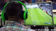 Ein Besucher spielt am 13.08.2014 in Köln (Nordrhein-Westfalen) auf der Spielemesse Gamescom das Computerspiel FIFA 15. Foto: Caroline Seidel | Verwendung weltweit