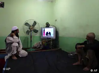 资料图片：阿富汗人观看卡尔扎伊在电视上发表竞选讲话