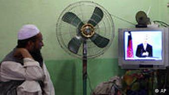 Zwei Afghanen schauen auf Amtsinhaber Hamid Karsai bei einer Wahlveranstaltung im Fernsehen (Foto: dpa)