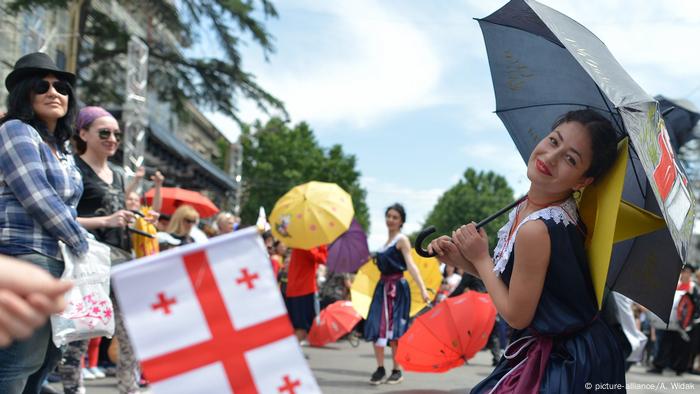 Dancers with umbrellas and Georgian flags (picture-alliance/A. Widak).