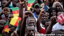 Supporters of the leader of the Cameroonian opposition party Movement for the Rebirth of Cameroon (MRC) rise their fists in Yaounde, on September 30, 2018 during a campaign rally for the presidential elections. - Cameroon imposed a 48-hour curfew on its English-speaking regions a day ahead of the one-year anniversary of a symbolic independence declaration by anglophone separatists, officials said on September 30, 2018. The anniversary comes ahead of October 7, 2018 polls that anglophone secessionists have threatened to disrupt. (Photo by MARCO LONGARI / AFP) (Photo credit should read MARCO LONGARI/AFP/Getty Images)