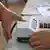 Eleitor coloca o polegar na máquina para identificação antes de votar