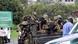 Soldiers brandish guns while sitting in the back of a pickup Soldiers brandish guns while sitting in the back of a pickup