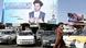 A man walks by cars with billboard ads of parliamentary candidates in the background A man walks by cars with billboard ads of parliamentary candidates in the background