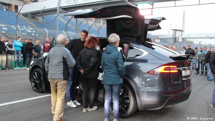 People gather round a Tesla vehicle in Lausitz