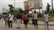 A group of people walking along a street in Benin City, southern Nigeria A group of people walking along a street in Benin City, southern Nigeria