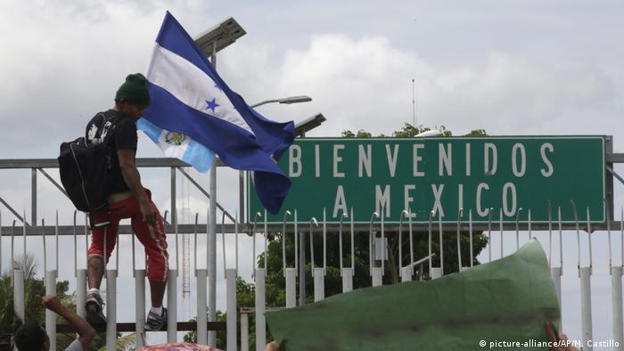 Foto simbólica de una persona con banderas de Guatemala y Honduras en la frontera con México en una imagen de archivo.