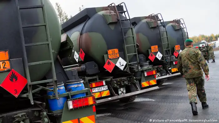 A soldier walks past German fuel tanks during NATO's Trident Juncture exercise in Norway (picture-alliance/dpa/M. Assanimoghaddam)