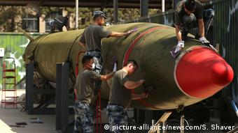 Китайские солдаты в музее подкрашивают снятую с вооружения ракету средней дальности Dongfeng 2