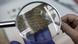 A fragment from the Dead Sea Scrolls under a magnifying glass A fragment from the Dead Sea Scrolls under a magnifying glass
