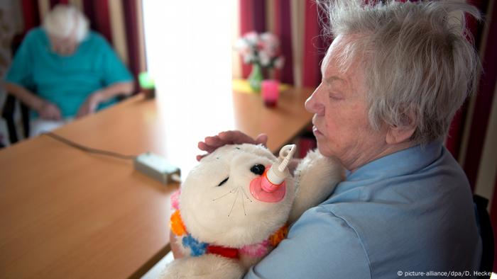 Eine Frau drück eine weiße Kuscheltierrobbe an sich und streichelt sie (Foto: Picture Alliance)