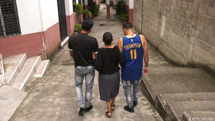 Dos hombres y una mujer caminan por un callejuela. (DW/Aitor Saez)