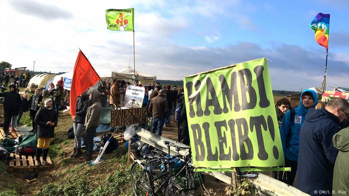 Zelený prapor s nápisem Hambach Forest zůstává v němčině na protestu proti uhlí v západním Německu