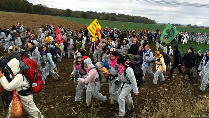 Los manifestantes cruzan un campo durante una protesta masiva contra el carbón en el oeste de Alemania.