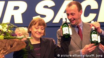 Фридрих Мерц поздравляет Ангелу Меркель с избранием председателем ХДС и вручает ей две бутылки игристого M&M, 2000 год