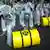 Demonstrators dressed in protective clothing roll yellow fake nuclear waste barrels across a road