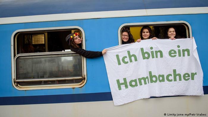 Czech activists hold up a banner from a train window: Ich bin ein Hambacher