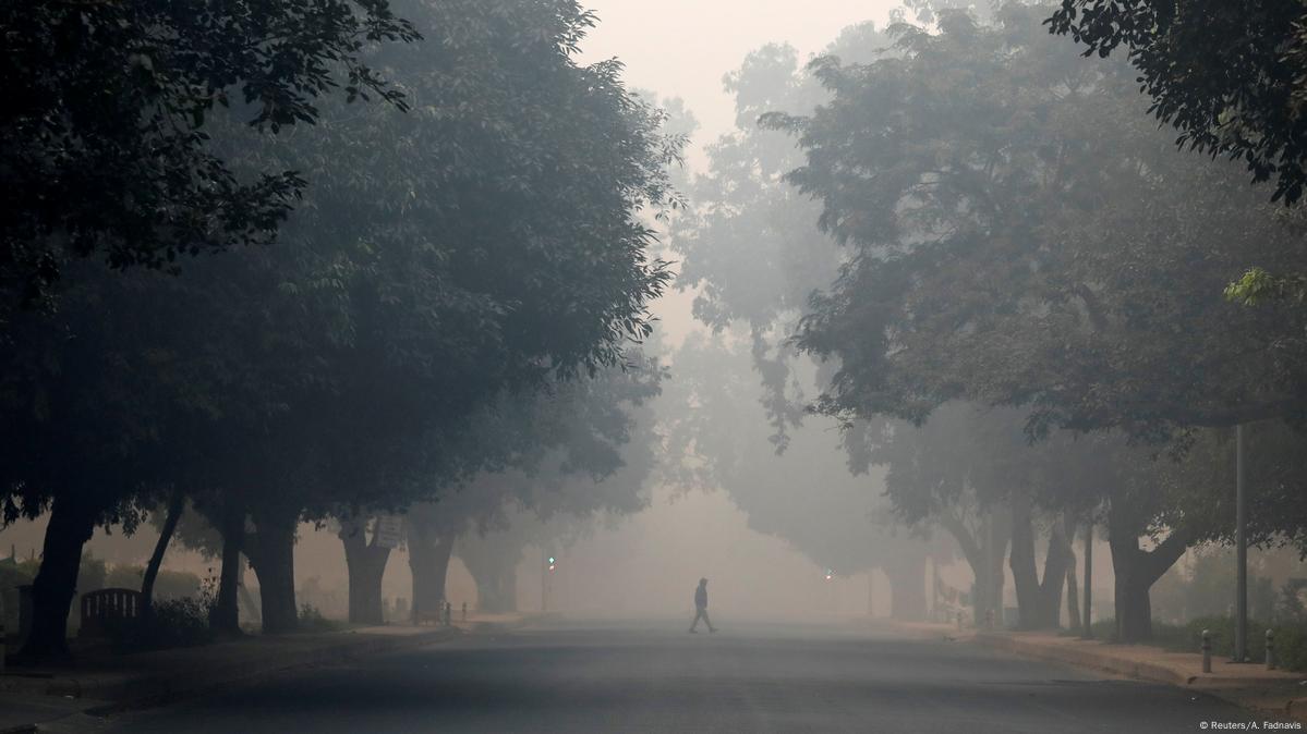 A man crosses a road on a smoggy morning in New Delhi