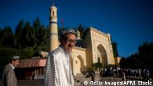 This picture taken on June 26, 2017 shows a Muslim man arriving at the Id Kah Mosque for the morning prayer on Eid al-Fitr in the old town of Kashgar in China's Xinjiang Uighur Autonomous Region. The increasingly strict curbs imposed on the mostly Muslim Uighur population have stifled life in the tense Xinjiang region, where beards are partially banned and no one is allowed to pray in public. Beijing says the restrictions and heavy police presence seek to control the spread of Islamic extremism and separatist movements, but analysts warn that Xinjiang is becoming an open air prison. / AFP PHOTO / Johannes EISELE