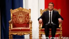 Emmanuel Macron sitzt auf einem rot-goldenen Stuhl (Getty Images/C. Platiau)