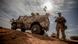 A German soldier standing next to an armoured vehicle A German soldier standing next to an armoured vehicle