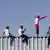 Мігранти на огорожі на кордоні між США та Мексикою