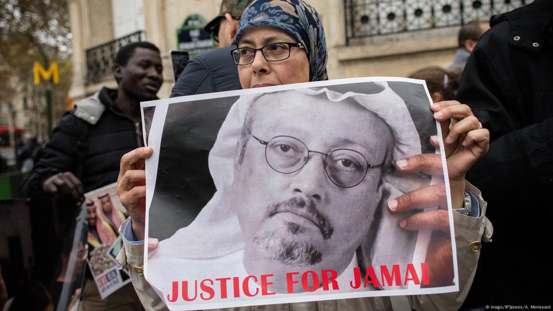 A woman holds a poster at a demonstration calling for justice for Jamal Khashoggi.