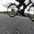 Bicicleta corre sobre malha de pastilhas fotovoltaicas que cobre ciclovia 