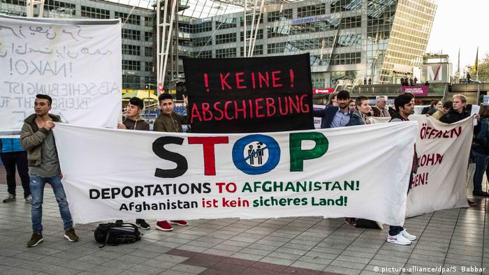 Protesters hold up anti-deportation signs at Munich's international airport