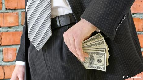 A picture of a man in a business suit putting money in his pocket