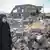 Woman walking past rubble in Kermanshah