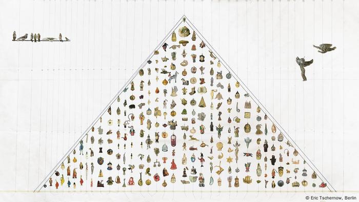 Man sieht ein dem Umriss des Weihnachtsbaums nachempfundenes Dreieck mit kleinen Männchen und Figuren, die aus anderen Kulturen kommen, wie zum Beispiel der chinesische Weihnachtsmann und der indonesische Schneemann (Eric Tschernow, Berlin)