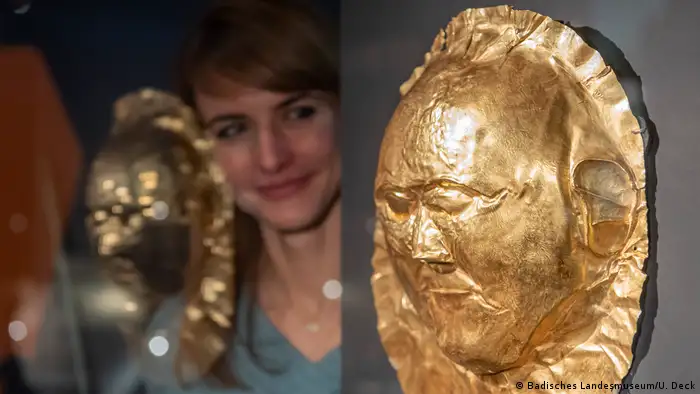  A woman looking at a golden mask (Badisches Landesmuseum/U. Deck)