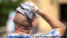 Mann mit Handtuch auf dem Kopf zum Abkühlen