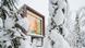 A small hut with a large picture window surrounded by a pine forest covered in snow in Rovaniemi, Finland A small hut with a large picture window surrounded by a pine forest covered in snow in Rovaniemi, Finland