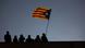 Silhouette of people with one person holding a Catalan independence flag Silhouette of people with one person holding a Catalan independence flag