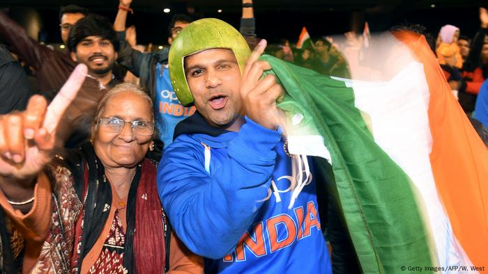 A man and a woman celebrate while waving the Indian flag (Getty Images/AFP/W. West)